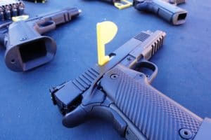 Unloaded handguns sit on a table alongside ammunition