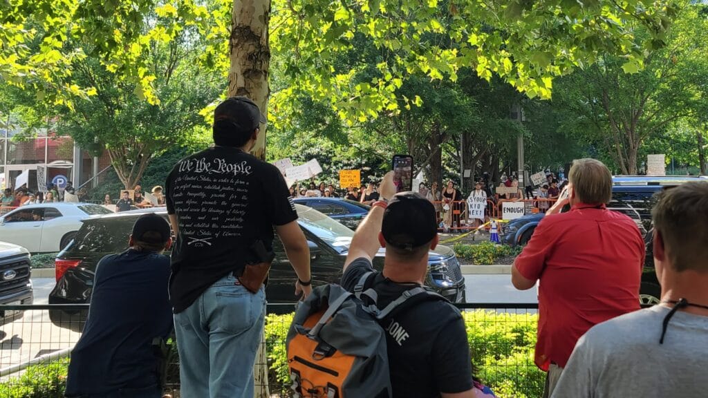 Gun-control protesters and NRA members shout at each other outside the group's 2022 Annual Meeting