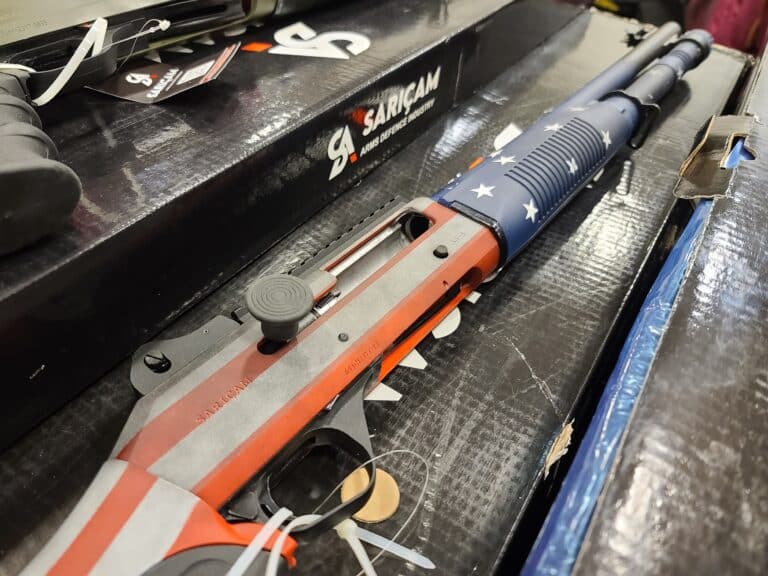 A semi-automatic shotgun with an American flag painted on it at a 2023 Virginia gun show