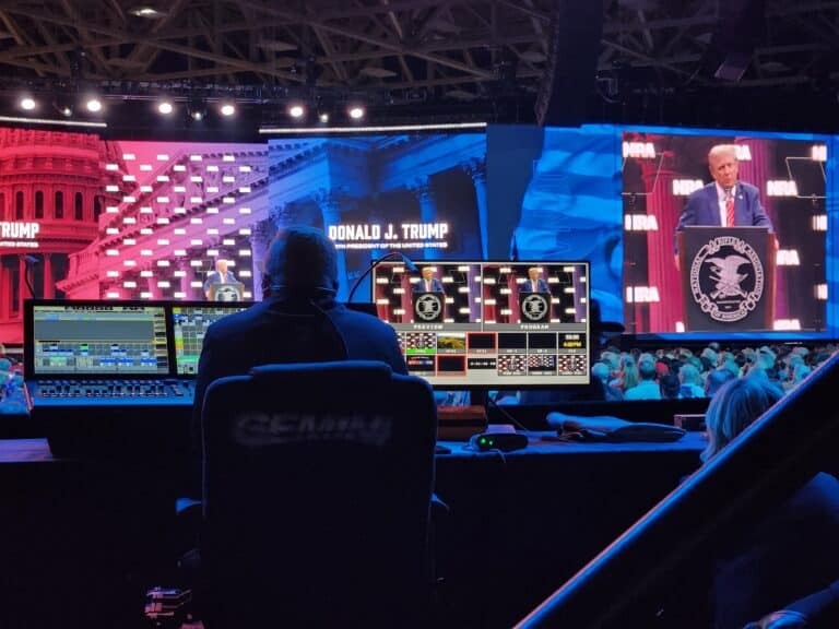 A producer watches monitors as Donald Trump gives a speech to the 2024 NRA Annual Meeting
