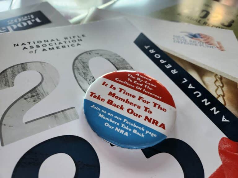 An NRA reform button sits on top the group's 2023 annual report