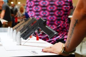 Attendees examine Sig Sauer pistols at the 2024 NRA Annual Meeting