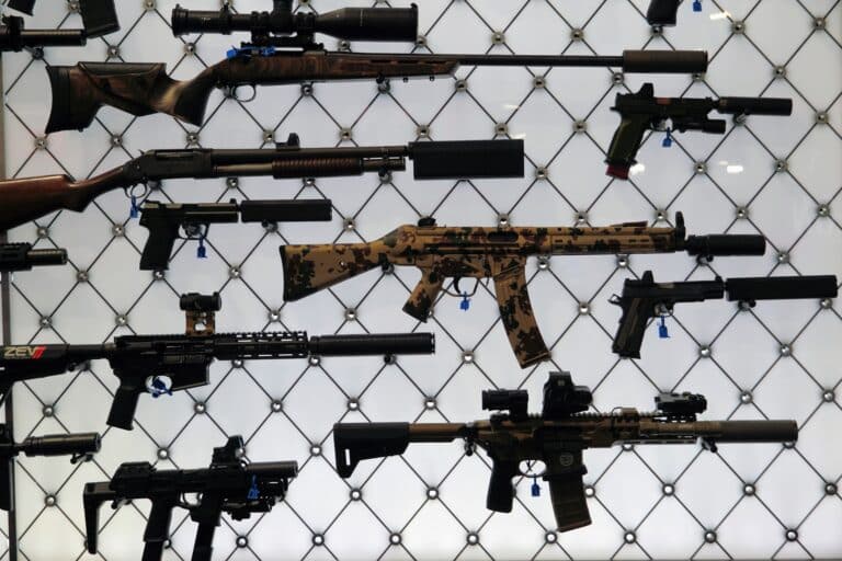 A collection of suppressed firearms on display at the SilencerCo booth during the 2025 NRA Annual Meeting