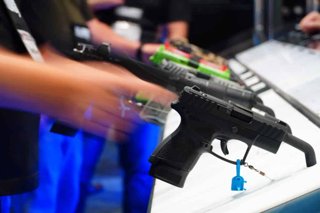 An attendee picks up a pistol at the 2025 NRA Annual Meeting