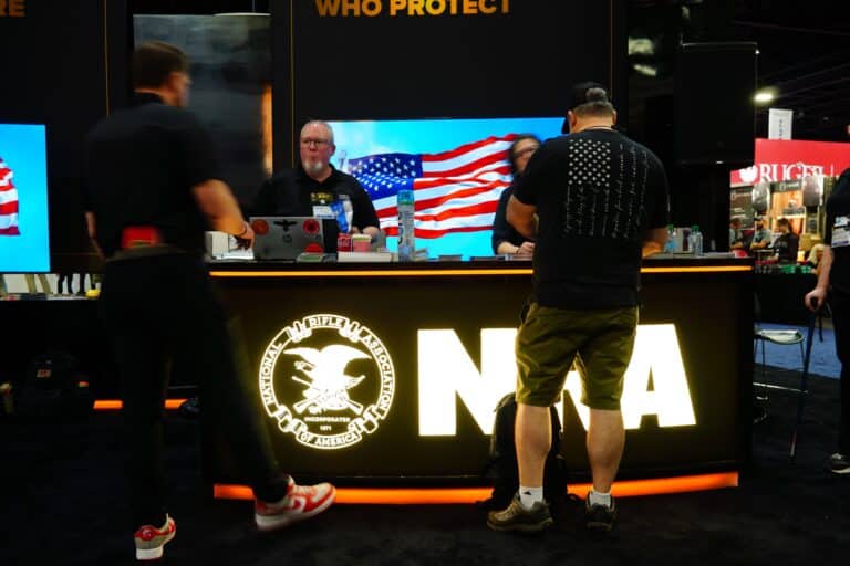 Attendees at the 2025 NRA Annual Meeting talk to staff